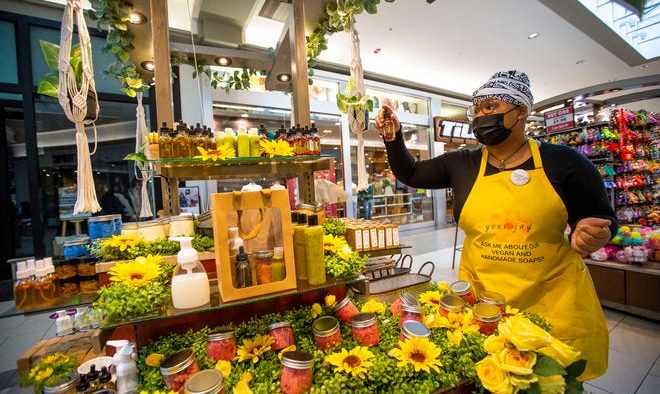 Zion Bradford shows off products Monday, Jan. 10, 2022, at the Yoni Jay kiosk inside the University Park Mall.