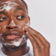 Black man cleansing and washing his face with soap
